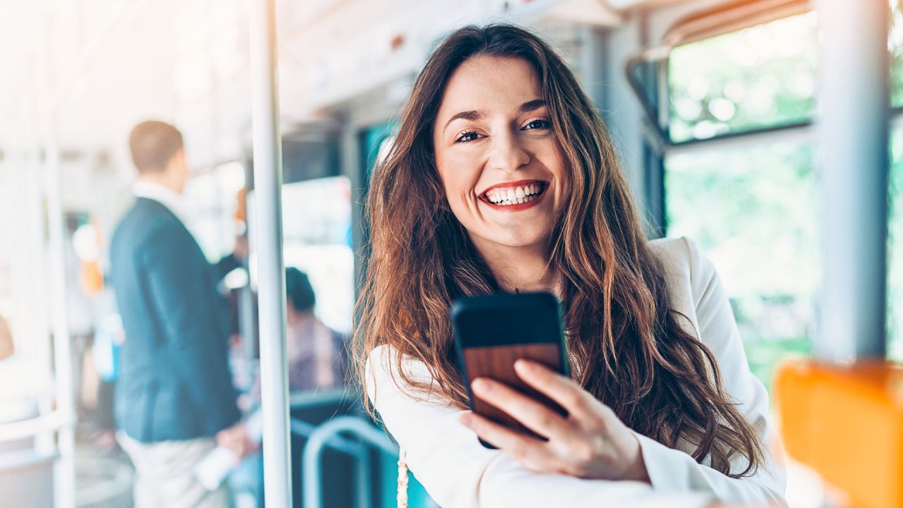 Eine Frau mit einem Mobiltelefon in der Hand im Zug